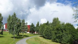 a red building sitting on the side of a lush green field